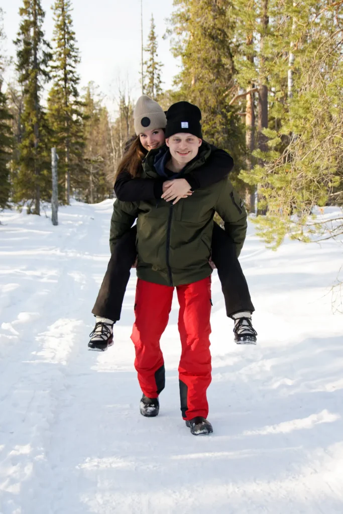 Couple amoureux dans la neige en montagne en hiver, capturant des photos naturelles.