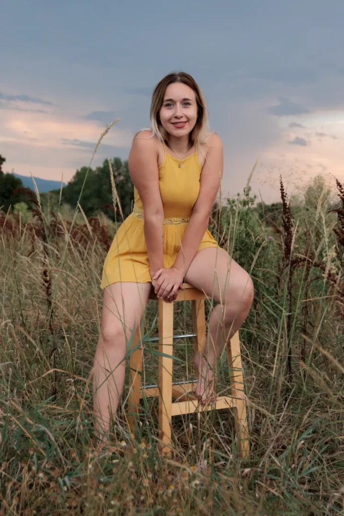 Portrait naturel d'une jeune femme sur un tabouret en plein champ